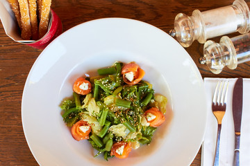 Salad with salmon, asparagus and melted cheese. sprinkled with sesame