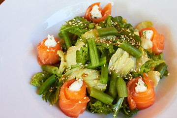 Salad with salmon, asparagus and melted cheese. sprinkled with sesame