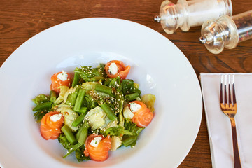 Salad with salmon, asparagus and melted cheese. sprinkled with sesame