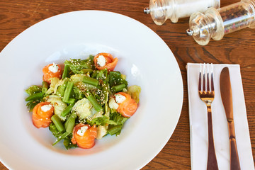 Salad with salmon, asparagus and melted cheese. sprinkled with sesame