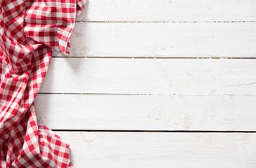 Red checkered kitchen tablecloth on wooden table.