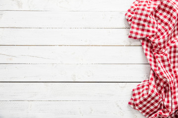 Red checkered kitchen tablecloth on wooden table.