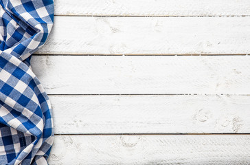 Blue checkered kitchen tablecloth on wooden table.
