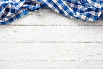 Blue checkered kitchen tablecloth on wooden table.
