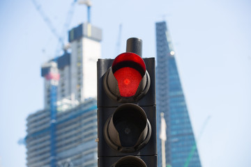 Red traffic light against of new skyscrapers at the background. City of London modern life