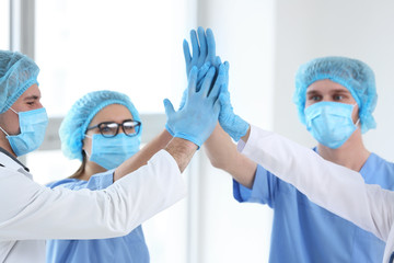 Team of doctors giving high five in clinic