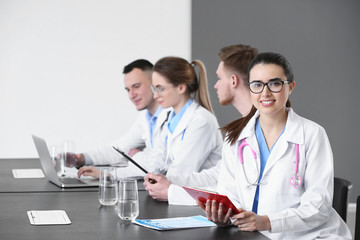 Young doctors sitting at table during meeting in clinic
