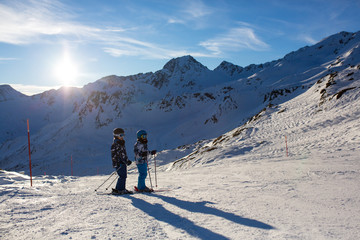 Fototapeta na wymiar Happy people, children and adults, skiing on a sunny day in Tyrol mountains