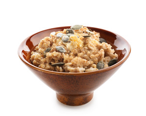 Bowl with tasty oatmeal on white background