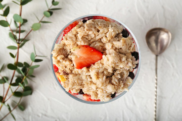 Bowl with tasty oatmeal on white table