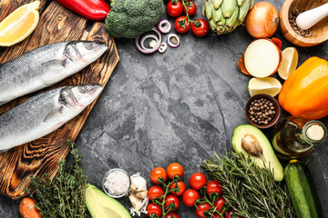 Frame made of raw seabass fish and products on grey background