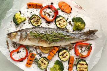 Tasty cooked seabass fish and vegetables on parchment
