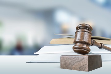 Justice Scales, books and gavel on dark