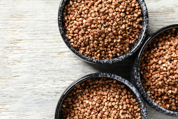 Bowls with raw buckwheat on table