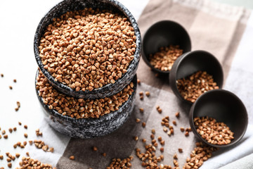 Bowls with raw buckwheat on table