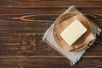 Plate with butter on wooden background