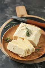 Plate with butter on grey background