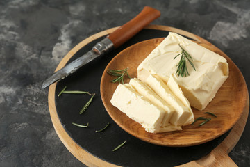 Plate with butter on grey background