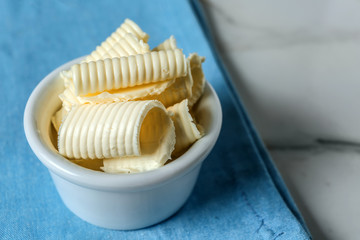 Bowl with butter curls on table
