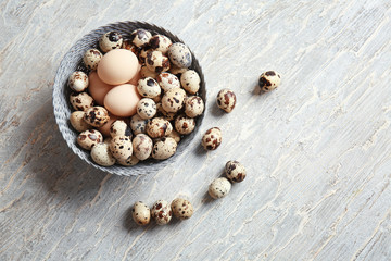 Fototapeta na wymiar Bowl with fresh quail and chicken eggs on table