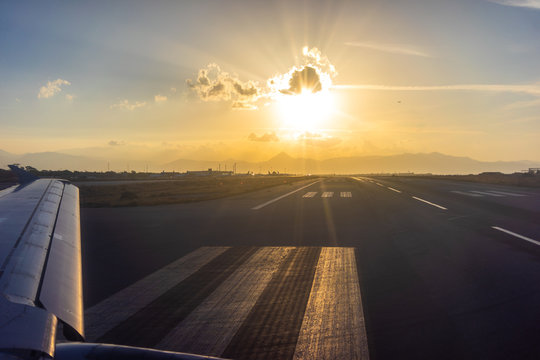 View of the wing of the aircraft from the porthole on the background of the runway