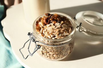 Glass jar with raw oatmeal on tray