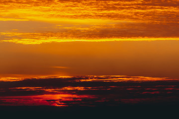Fototapeta na wymiar Sunny shine on clouds. Wonderful vivid dawn. Beautiful calm orange sunset. Scenic surreal sunrise. Amazing red cloudy sky. Picturesque sundown. Atmospheric cloudscape. Circle of sun above horizon.