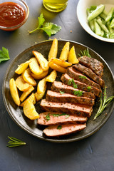 Medium rare roast beef with potato wedges