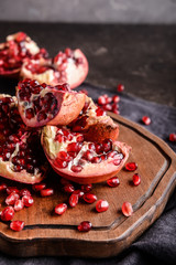 Board with ripe pomegranates on table