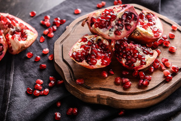 Board with ripe pomegranates on table