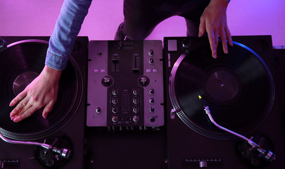 Female DJ playing music in club, top view