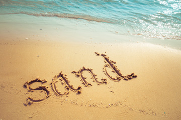 Vacation on the sand beach concept. Sand words written into the sand on the beach at Rayong, Thailand