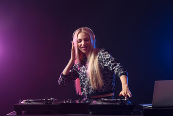 Fototapeta na wymiar Female DJ playing music in club