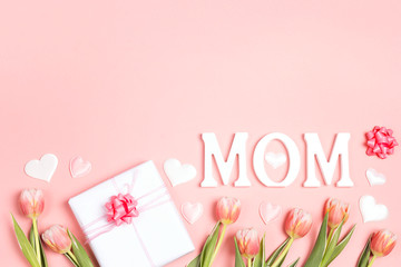 Mothers day message with tulips and gift on pink background. Copy space.