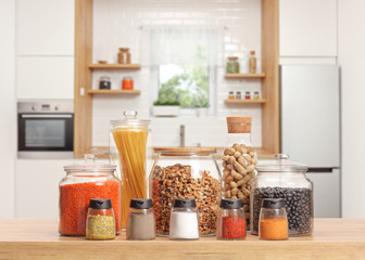 Fototapeta na wymiar Many glass jars with different ingredients and spices on a kitchen worktop