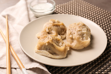Plate with tasty dumplings on table