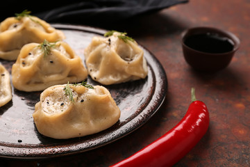 Plate with tasty dumplings on table, closeup