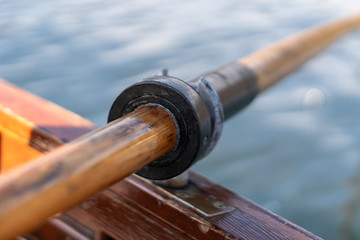 Closeup photo of wooden paddle attached to boat used for rowing in the water, lake Bled on a sunny...