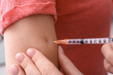 Diabetic woman receiving insulin injection, closeup