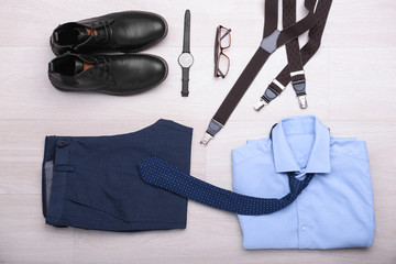 Set of male clothes and accessories on wooden background