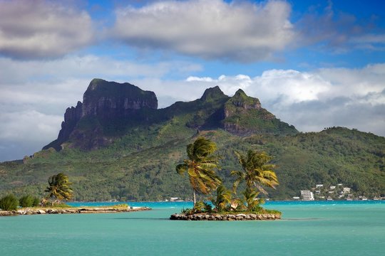 Small palm island in the sea in front of Mont Otemanu, Bora Bora Island, Society Islands, French Polynesia, Oceania