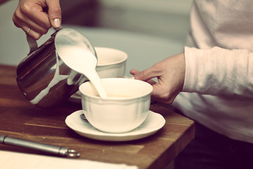 Young woman making cup of coffee in a bar, close up vintage view