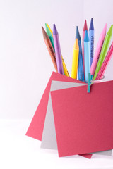 Fototapeta premium Colorful crayons with red and gray blank notes