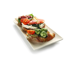 Plate with fresh tasty bruschettas on white background