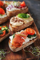 Fresh tasty bruschettas on wooden board