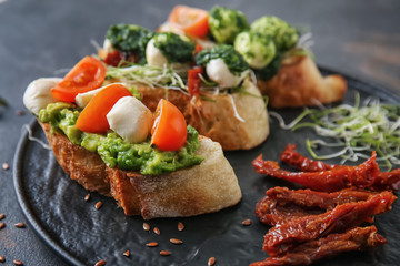 Plate with fresh tasty bruschettas on grey background