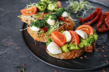 Plate with fresh tasty bruschettas on grey background