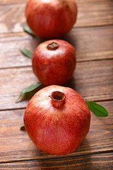 Fototapeta na wymiar Ripe pomegranates on wooden table