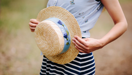 Beautiful woman and boater straw hat with blue decor in summer