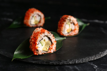 Tasty sushi rolls on slate plate